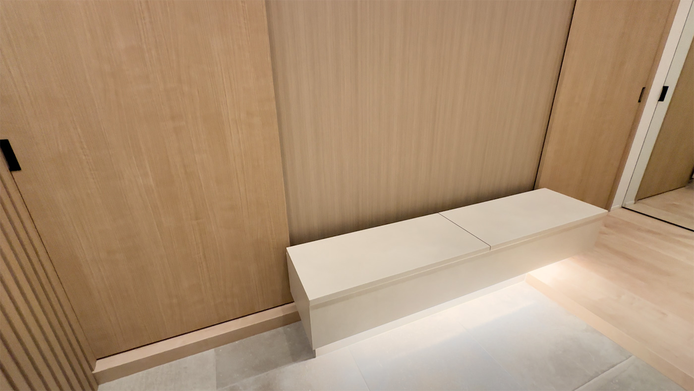 ベンチの天板は開閉式で内部は収納に。下部の床面を照らす照明は空間の広がりを生み出します。