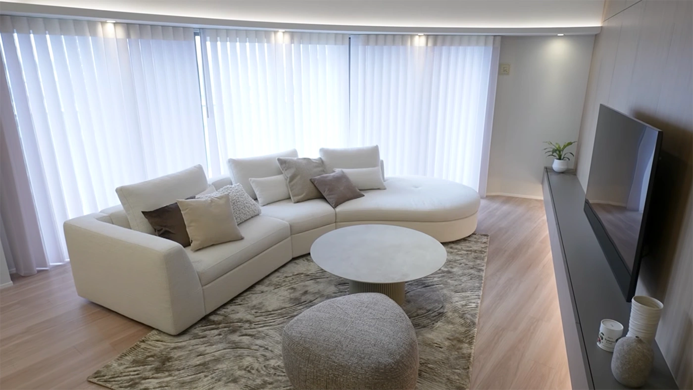 After - 天井の曲線と調和する、BoConceptのソファを配した美しいリビング。