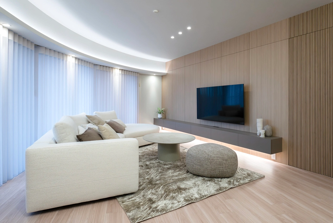 After - 天井の曲線と調和する、BoConceptのソファを配した美しいリビング。